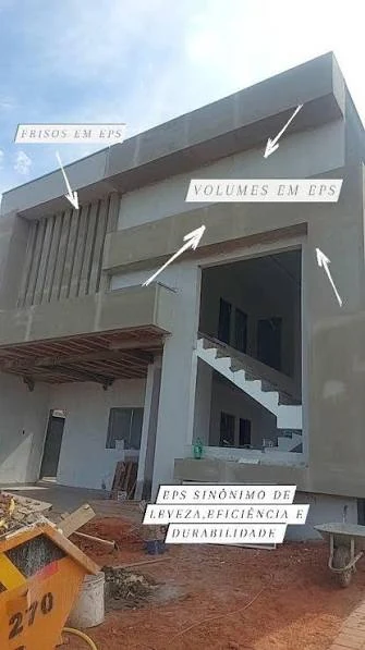 Fachada em obra com volumetria em EPS: frisos verticais e volumes revestidos com argamassa, indicados por setas